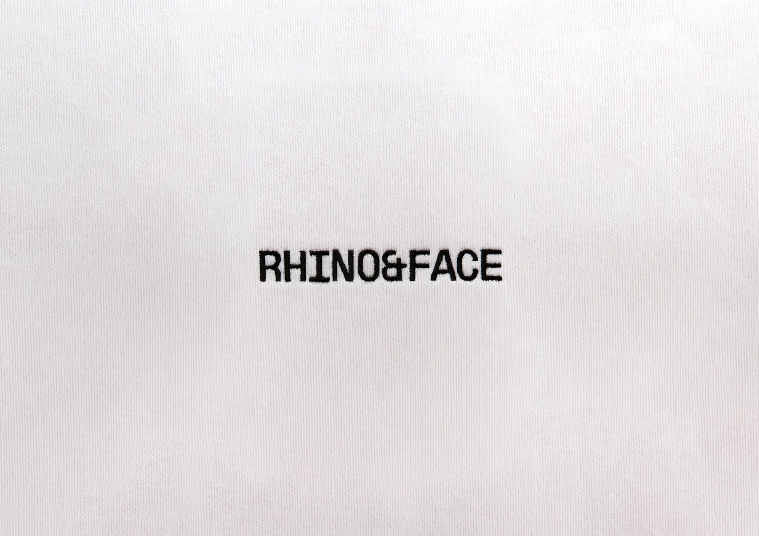 Logotipo de Rhino & Face sobre tejido blanco